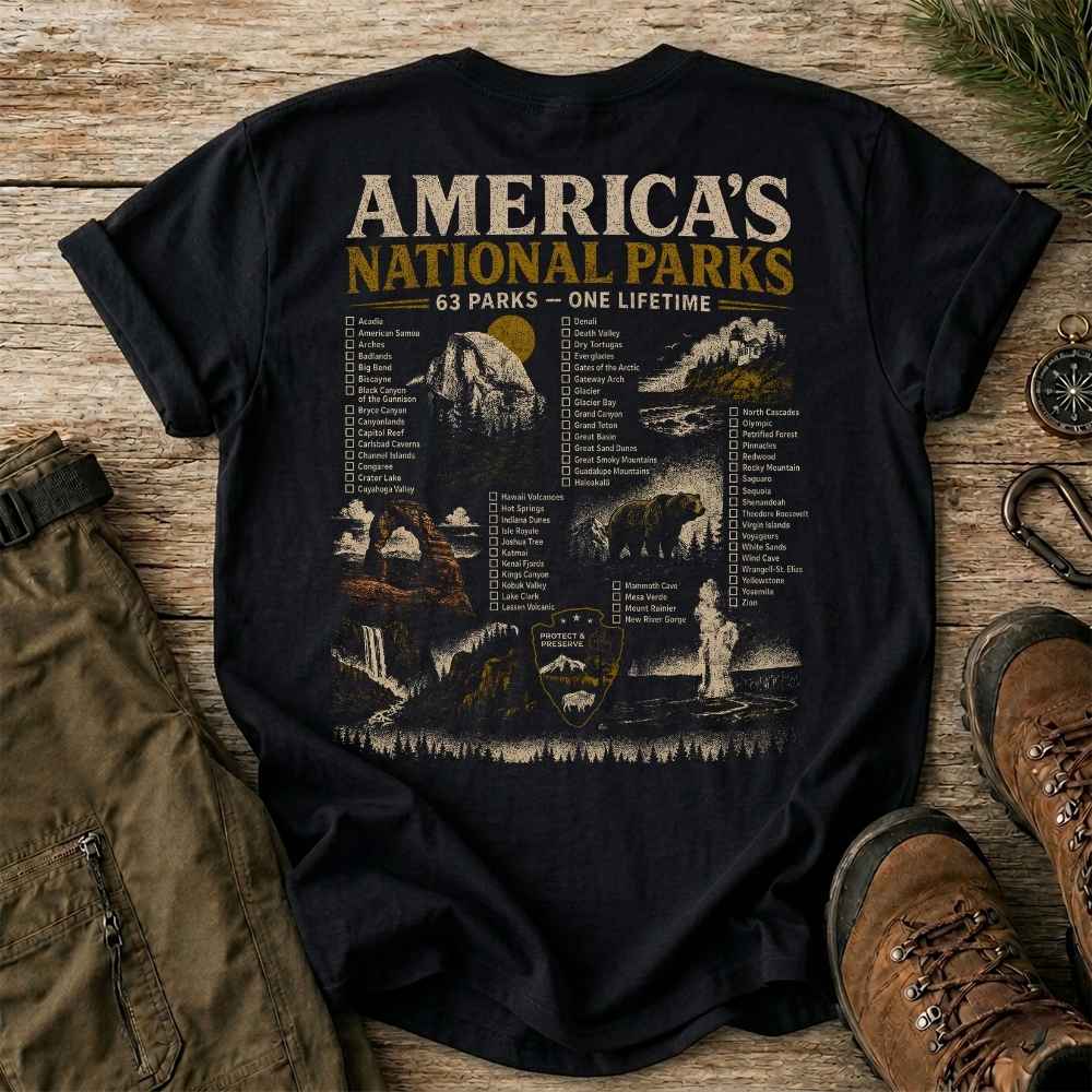 Black t-shirt with 'America's National Parks' graphic on a wooden surface with hiking gear.