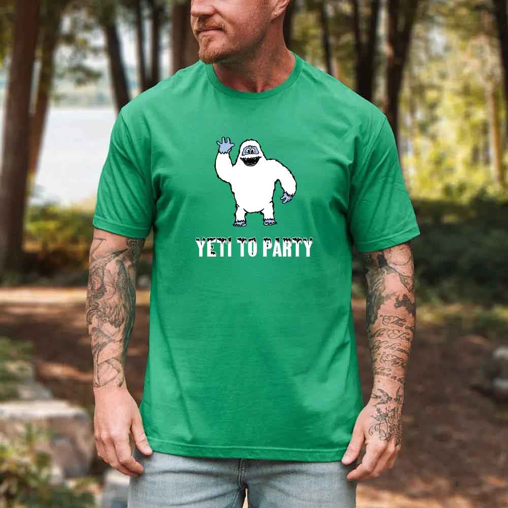 Man wearing a green t-shirt with a graphic of a yeti and 'Yeti to Party' text, standing outdoors.