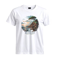 Thumbnail for May include a White Breathe Deep Keep It Simple T-Shirt featuring a scenic coastal landscape with ocean waves, rocky cliffs, a windswept tree, and an inspirational nature graphic.