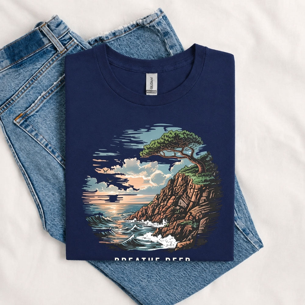 May include a Navy Breathe Deep Keep It Simple T-Shirt featuring a scenic coastal landscape with ocean waves, rocky cliffs, a windswept tree, and an inspirational nature graphic.