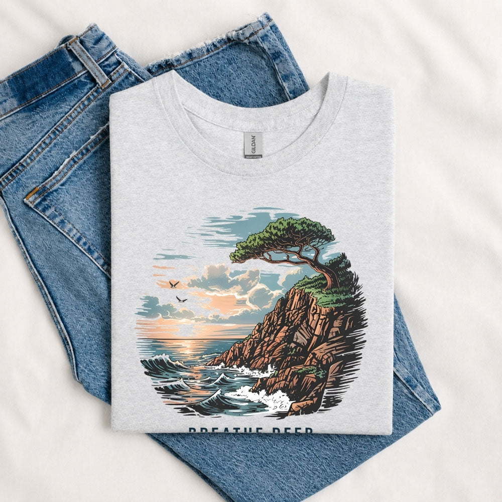 May include a Sport Grey Breathe Deep Keep It Simple T-Shirt featuring a scenic coastal landscape with ocean waves, rocky cliffs, a windswept tree, and an inspirational nature graphic.