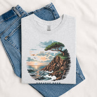 Thumbnail for May include a Sport Grey Breathe Deep Keep It Simple T-Shirt featuring a scenic coastal landscape with ocean waves, rocky cliffs, a windswept tree, and an inspirational nature graphic.
