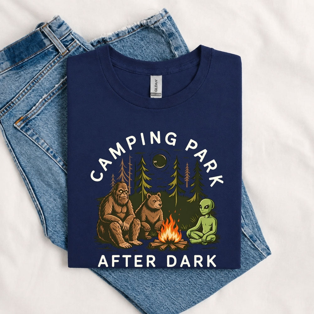 May include a Navy Camping Park After Dark T-Shirt featuring alien, Bigfoot, and bear camping graphics with a nighttime forest scene for campers, hikers, and outdoor adventure enthusiasts.