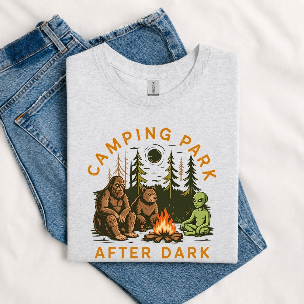 May include a Sport Grey Camping Park After Dark T-Shirt featuring alien, Bigfoot, and bear camping graphics with a nighttime forest scene for campers, hikers, and outdoor adventure enthusiasts.