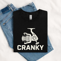 Thumbnail for May include a Black funny Cranky Fishing graphic printed on a unisex cotton T-shirt featuring a humorous fish lover design for men and women.