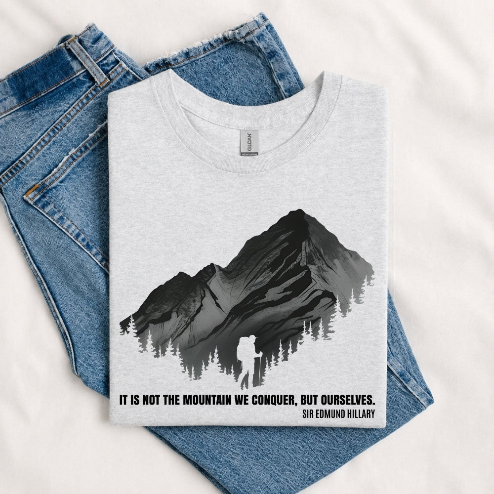 May include a Sport Grey It Is Not the Mountain We Conquer but Ourselves T-Shirt featuring an inspirational mountain quote graphic for hikers, climbers, campers, and mountain lovers.