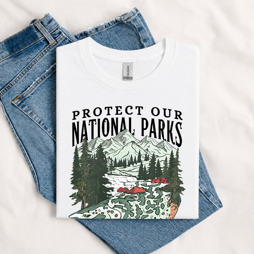 May include a White Protect Our National Parks Fish X River Graphic T-Shirt featuring a fish silhouette with a scenic river landscape for anglers, hikers, campers, and nature lovers.