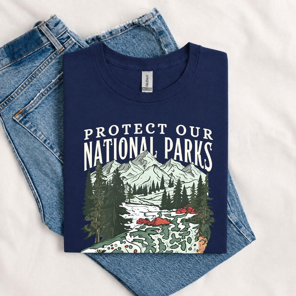 May include a Navy Protect Our National Parks Fish X River Graphic T-Shirt featuring a fish silhouette with a scenic river landscape for anglers, hikers, campers, and nature lovers.