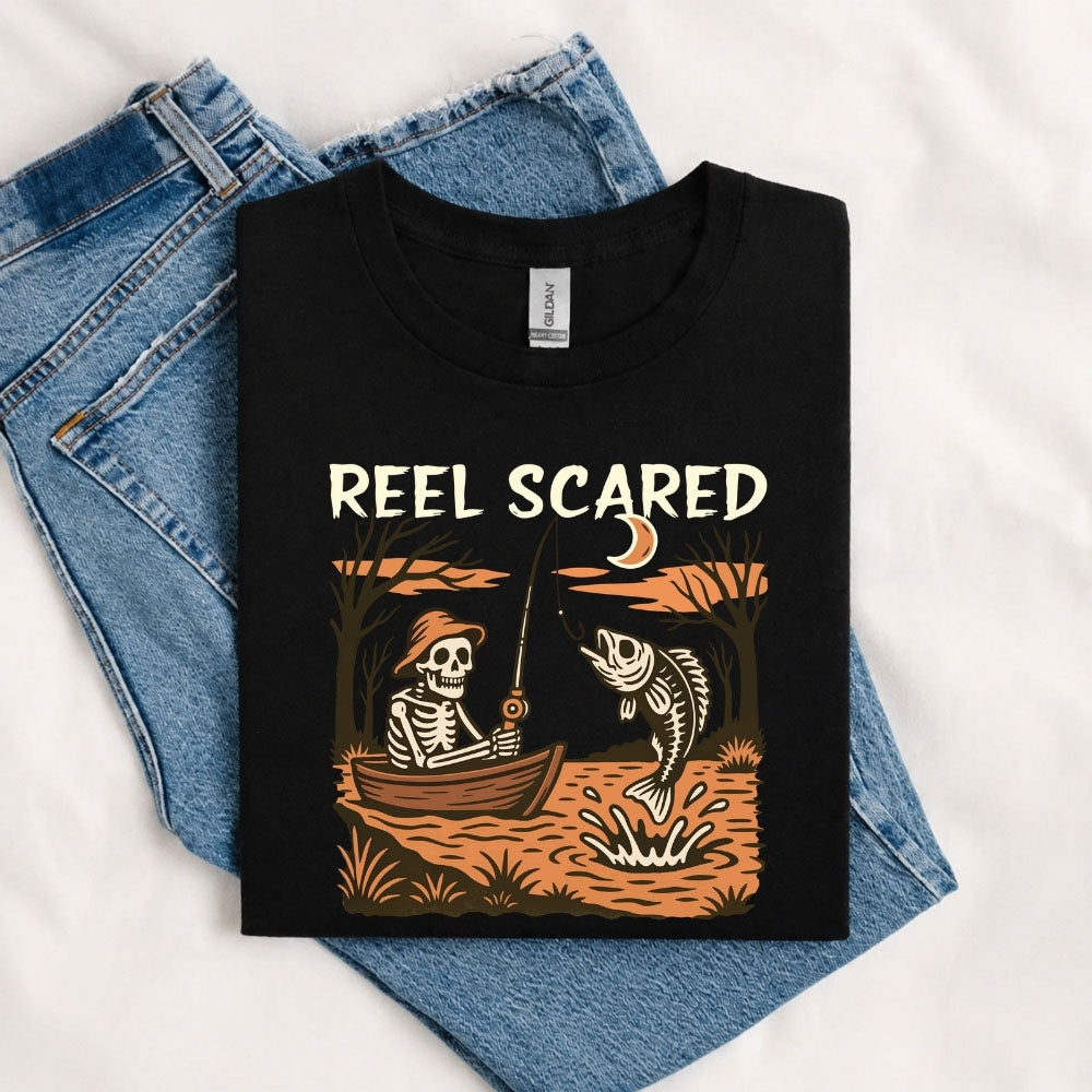 May include a Black person wearing the Reel Scared Halloween T-Shirt featuring a funny fishing-inspired Halloween graphic for spooky season celebrations.