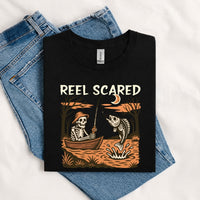 Thumbnail for May include a Black person wearing the Reel Scared Halloween T-Shirt featuring a funny fishing-inspired Halloween graphic for spooky season celebrations.