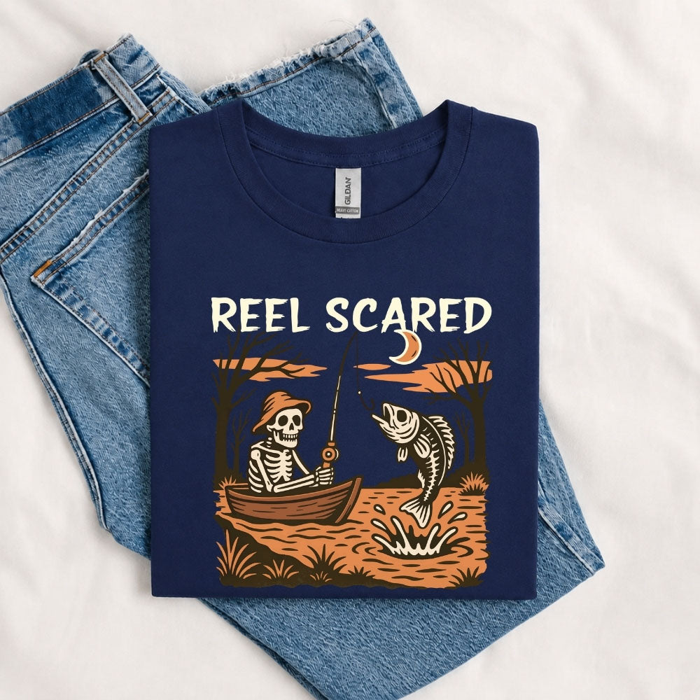 May include a Navy person wearing the Reel Scared Halloween T-Shirt featuring a funny fishing-inspired Halloween graphic for spooky season celebrations.