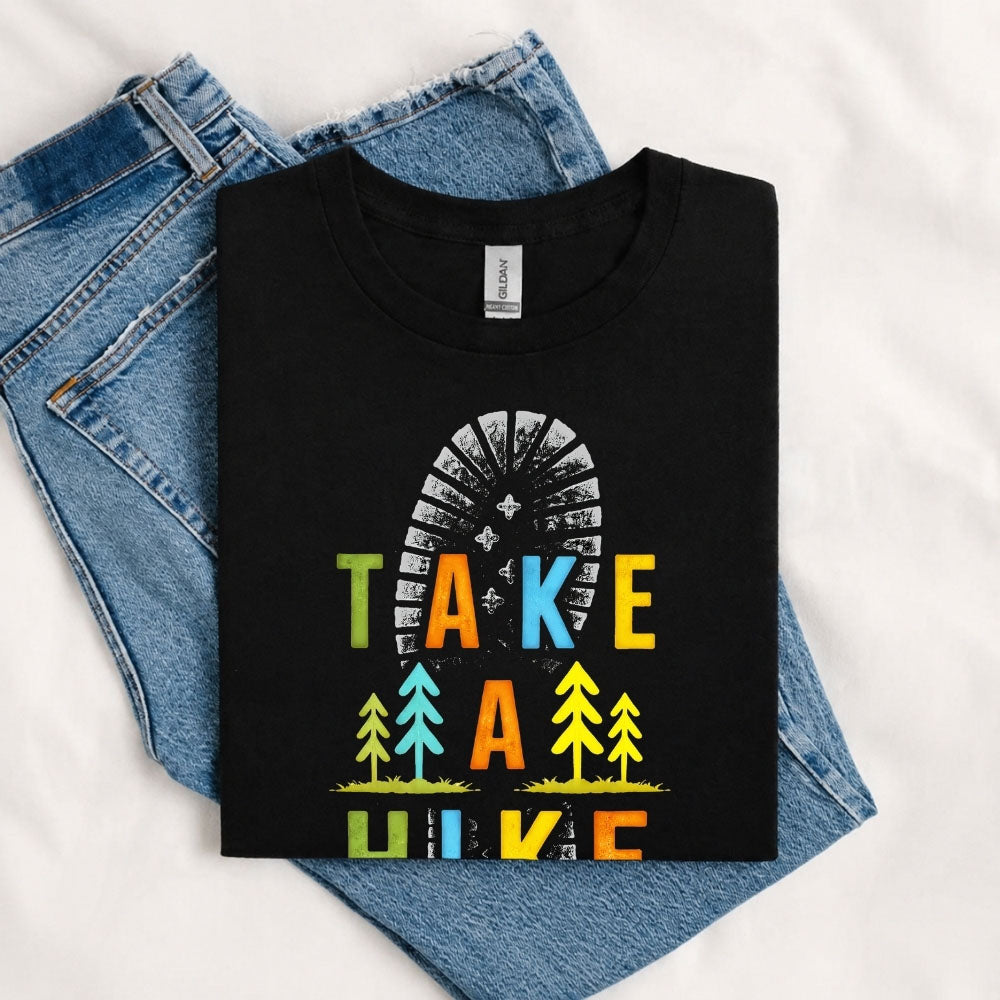 May include a Black Take A Hike Boot Print T-Shirt featuring a hiking boot print graphic with a funny outdoor quote for hikers, campers, backpackers, and nature lovers.