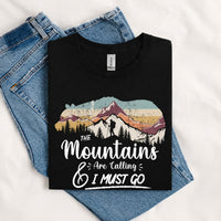 Thumbnail for May include a Black The Mountains Are Calling and I Must Go T-Shirt featuring an inspirational mountain graphic for hikers, campers, backpackers, and outdoor adventure lovers.
