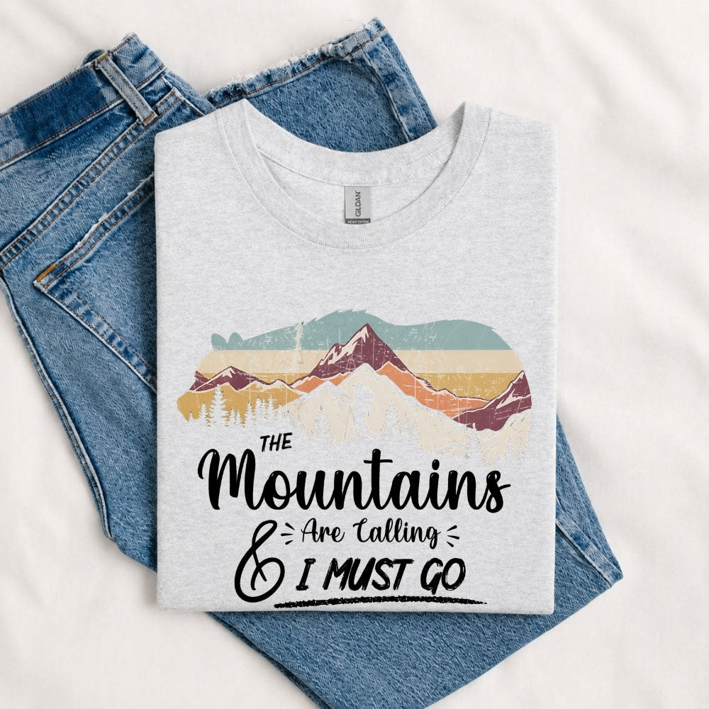 May include a Sport Grey The Mountains Are Calling and I Must Go T-Shirt featuring an inspirational mountain graphic for hikers, campers, backpackers, and outdoor adventure lovers.